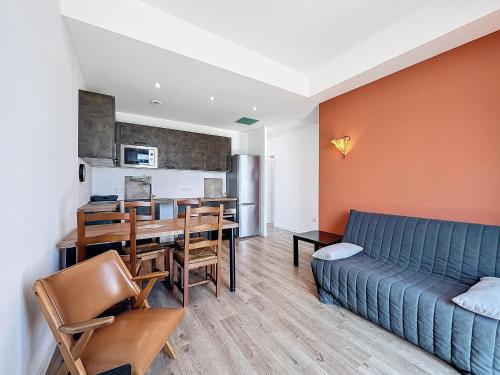 un salon avec un canapé bleu et une table dans l'établissement Confortable T3 sur plage avec WiFi et parking privé - FR-1-715-104, à Mauguio