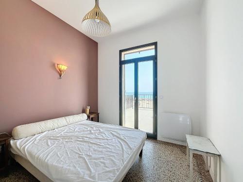 une chambre avec un lit et une grande fenêtre dans l'établissement Confortable T3 sur plage avec WiFi et parking privé - FR-1-715-104, à Mauguio
