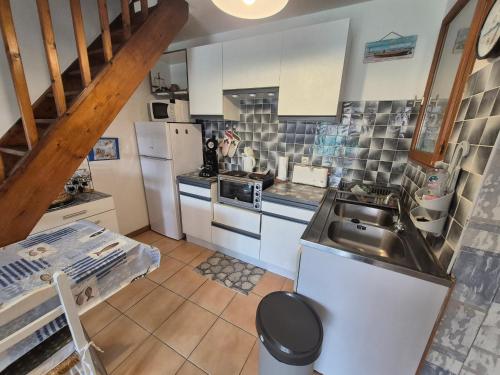 une cuisine avec des armoires blanches et un évier dans l'établissement Maison Climatisée 4 Pers, Parking, Argelès-sur-Mer - FR-1-776-136, à Argelès-sur-Mer