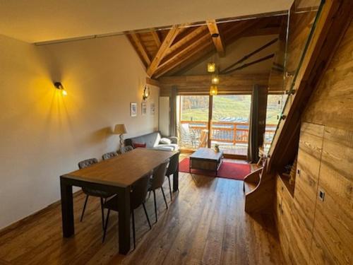 une salle à manger avec une table et un salon dans l'établissement Appartement Prestige 9 Pers - Terrasse Sud - Face aux Pistes - Animaux Admis - Garage - FR-1-445-220, à Montgenèvre
