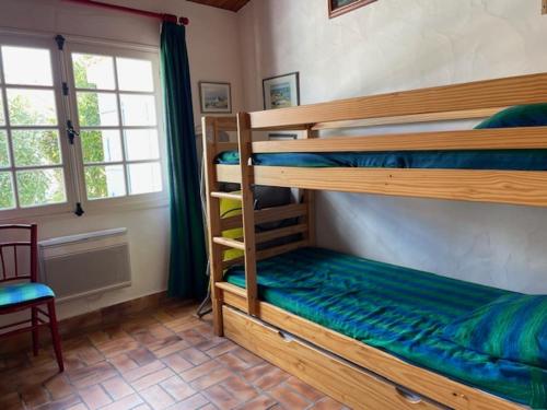 - une chambre avec 2 lits superposés et une chaise dans l'établissement Maison calme Noirmoutier 7 pers - WiFi & parking - FR-1-823-154, à Noirmoutier-en-l'lle
