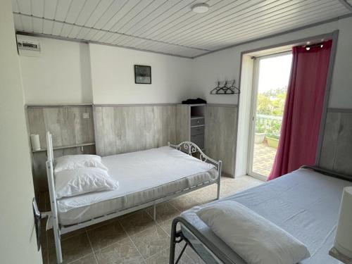 deux lits dans une chambre avec une fenêtre dans l'établissement Appartement 5 pers, accès privé au lac, piscine - FR-1-822-16, à Esparron-de-Verdon