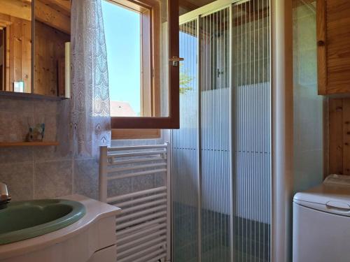 une salle de bain avec un lavabo et une douche en verre dans l'établissement Chalet authentique près de la plage pour 6 personnes - FR-1-788-65, à Merville-Franceville-Plage
