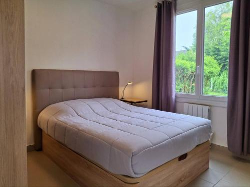 une chambre avec un grand lit avec une fenêtre dans l'établissement À 300 m de la plage, charme et tranquillité à Merville-Franceville - FR-1-788-66, à Merville-Franceville-Plage