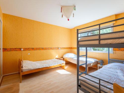 deux lits superposés dans une chambre aux murs jaunes dans l'établissement Grande Villa 14 Pers - Vue Imprenable sur Lac - Tranquillité à Biscarrosse - FR-1-319-605, à Biscarrosse