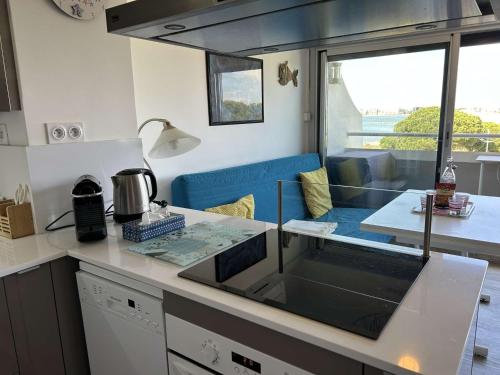 une cuisine avec un comptoir et une table dans l'établissement Appartement climatisé 2 pièces avec parking près de la plage - FR-1-250-309, au Grau-du-Roi