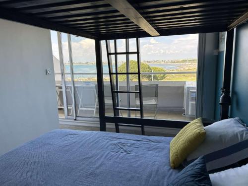 une chambre avec un lit et une vue sur l'océan dans l'établissement Appartement climatisé 2 pièces avec parking près de la plage - FR-1-250-309, au Grau-du-Roi