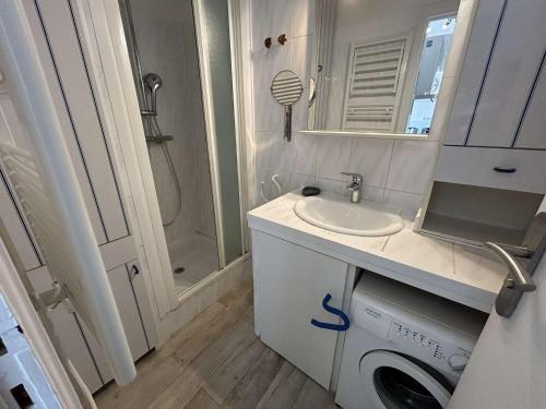une salle de bain avec un lavabo et une machine à laver dans l'établissement Appartement climatisé 2 pièces avec parking près de la plage - FR-1-250-309, au Grau-du-Roi