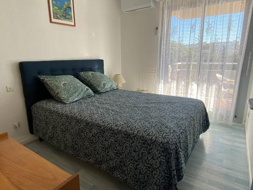une chambre avec un lit et une grande fenêtre dans l'établissement Charmant Deux-Pièces Climatisé à Canet-Plage - FR-1-750-87, à Canet
