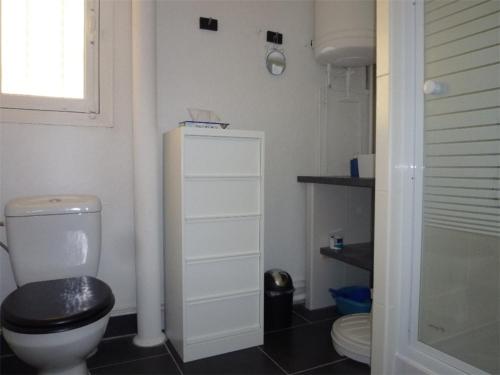 La salle de bains est pourvue de toilettes et d'un siège noir. dans l'établissement Studio-Alcôve avec balcon vue mer, 4 pers, centre-ville - FR-1-750-88, à Canet