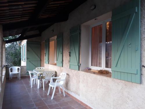 d'une terrasse avec des chaises blanches, une table et des fenêtres. dans l'établissement Villa provençale avec jardin et parking pour 4 personnes près du centre de Riez - FR-1-822-17, à Riez