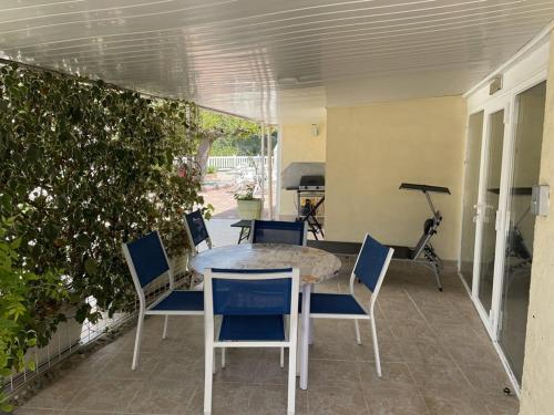 une terrasse avec une table, des chaises et une plante dans l'établissement Appartement charmant 4 pers avec accès privé au lac - FR-1-822-19, à Esparron-de-Verdon