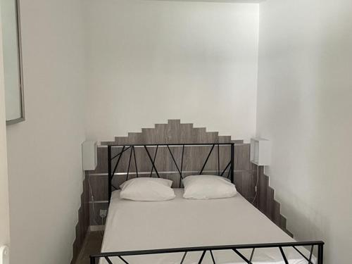 - un lit avec une tête de lit en métal dans l'établissement Appartement charmant 4 pers avec accès privé au lac - FR-1-822-19, à Esparron-de-Verdon