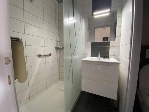 une salle de bain blanche avec un lavabo et une douche dans l'établissement Deux-pièces 2* avec Parking pour 4 pers. - Port Canet - FR-1-750-92, à Canet
