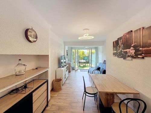 une cuisine et une salle à manger avec une table et des chaises en bois dans l'établissement Charmant T2 refait à neuf avec jardin et parking à St Cyr sur Mer, proche plage - FR-1-770-48, à Saint-Cyr-sur-Mer