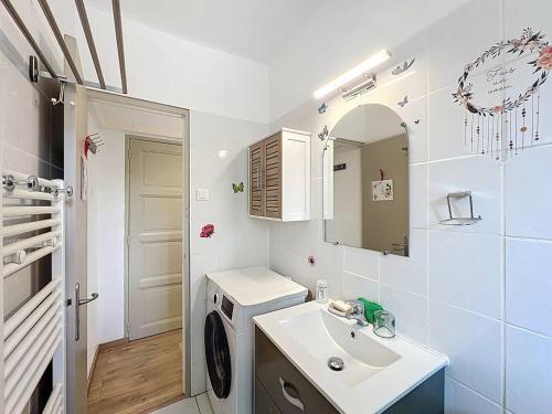 une salle de bain avec un lavabo et une machine à laver dans l'établissement Charmant T2 refait à neuf avec jardin et parking à St Cyr sur Mer, proche plage - FR-1-770-48, à Saint-Cyr-sur-Mer