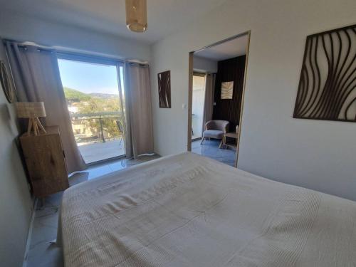 une chambre avec un grand lit et une grande fenêtre dans l'établissement Charmant appartement à Cavalaire-sur-Mer avec terrasse - FR-1-100-354, à Cavalaire-sur-Mer