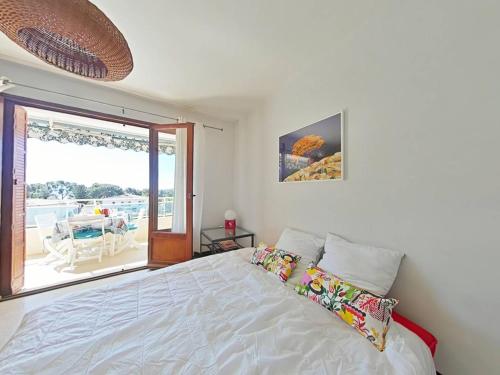 - une chambre avec un lit blanc et un balcon dans l'établissement Appartement 2P à Bormes-les-Mimosas avec accès piscine - FR-1-251-859, à Bormes-les-Mimosas