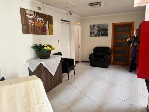 a man is standing in a living room at Hotel Plaza Los Leones in Curanilahue
