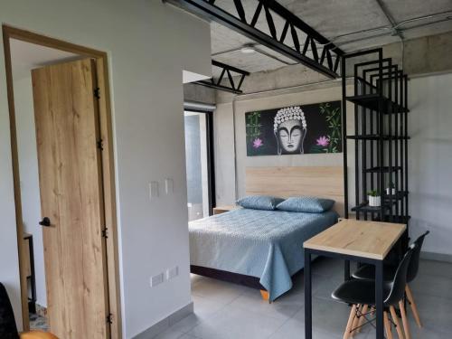 ein Schlafzimmer mit einem Bett und einem Schreibtisch in einem Zimmer in der Unterkunft Acogedor apartamento en Santa Rosa de Cabal in Santa Rosa de Cabal