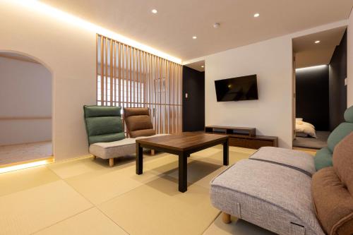 a living room with a couch and a table at 御宿こだま in Matsumoto
