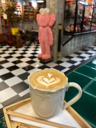 a cup of coffee with a teddy bear on a table at Years 1981 in Bangkok