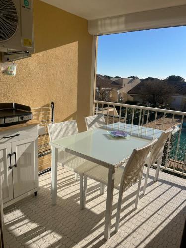 une table blanche et des chaises sur un balcon dans l'établissement 2 bedroom apartment, sleeps 4, à Fleury