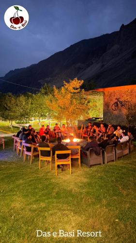 a group of people sitting around a table in a field at Das-e-Basi in Gilgit