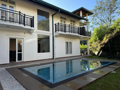 a house with a swimming pool in front of it at Winsanda Bungalow, Nuwara Eliya in Nuwara Eliya