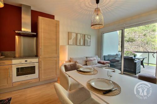 une cuisine et un salon avec une table et un canapé dans l'établissement Les bains, à Pléneuf-Val-André