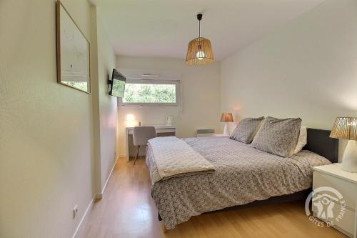 a bedroom with a bed and a desk and a window at Les bains in Pléneuf-Val-André