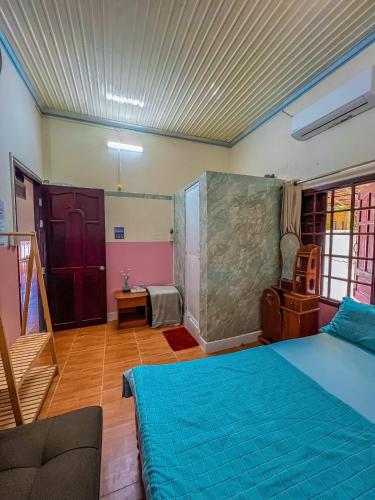 a bedroom with a blue bed and a staircase at Lê Huỳnh Guest House Family in Ke Ga