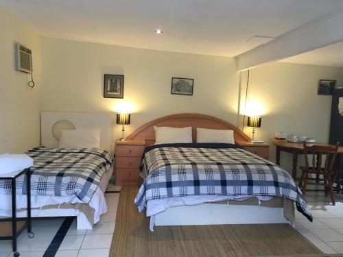a bedroom with two beds and a table and a desk at Downer Studio - Inner North, Near Chinatown, EPIC in Watson