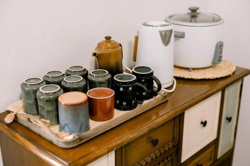 a counter with a tray with coffee cups and a pot at Stay Sa Amu - 4BR House in Capitol Area Cebu in Cebu City