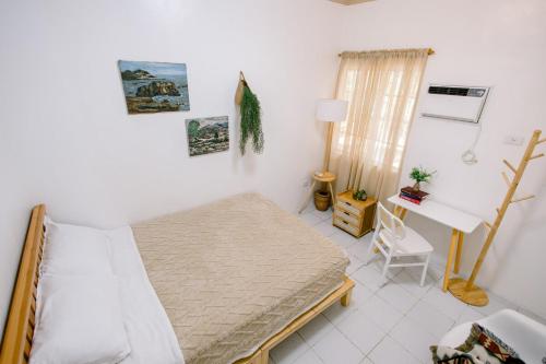 a bedroom with a bed and a desk in it at Stay Sa Amu - 4BR House in Capitol Area Cebu in Cebu City