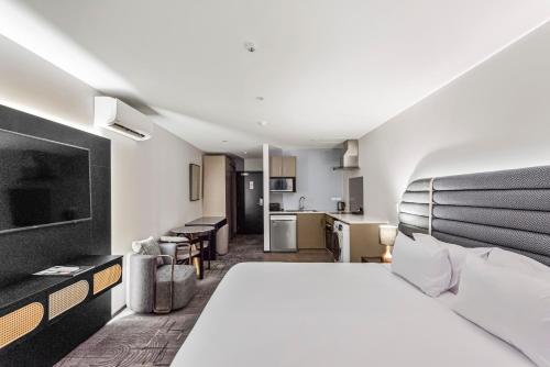 a hotel room with a large bed and a kitchen at Marsden Suites Albany in Albany