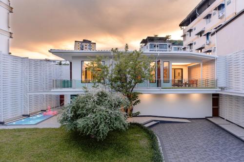 a large white house with a tree in the yard at PureLux6 - 3BR Pool Villa in Chiang Mai