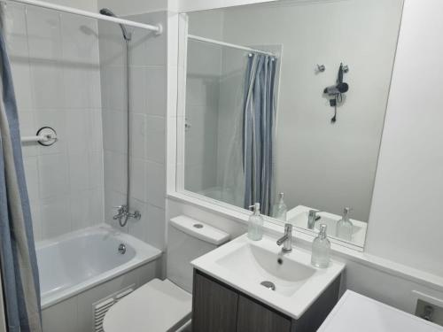 a white bathroom with a sink and a toilet at Departamento Centro Puerto Montt in Puerto Montt