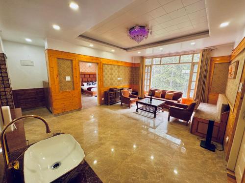 a bathroom with a sink and a living room at Staynest BNB in city Centre - 3 BHK apartments - PRIVATE PARKING - BALCONY VIEW in Shimla