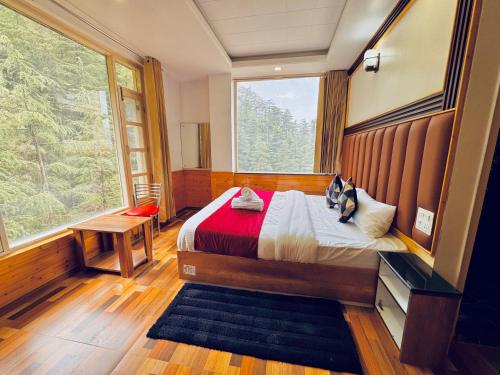 a bedroom with a bed and a large window at Staynest BNB in city Centre - 3 BHK apartments - PRIVATE PARKING - BALCONY VIEW in Shimla