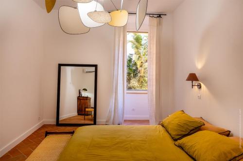 une chambre avec un lit, une fenêtre et un miroir dans l'établissement Ancien séminaire de la citadelle de Bastia, à Bastia