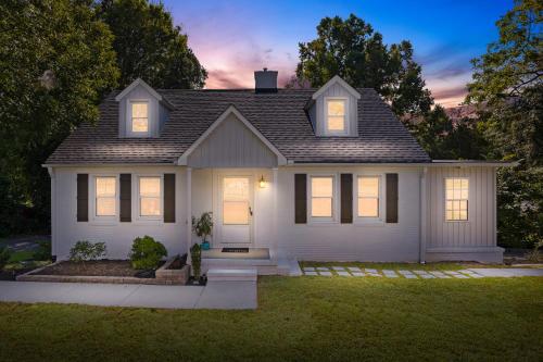 a white house with lights on in the yard at 4 BR - King beds - perfect for HPU, Furniture Market, Greensboro, Winston in High Point