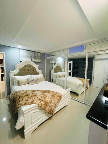 a bedroom with a large white bed with a large mirror at 2 Bedrooms 2 Bathrooms Luxury Gated Condo with Beach and Breathtaking Views of Kingston Harbour and 2 swimming Pools in Portmore