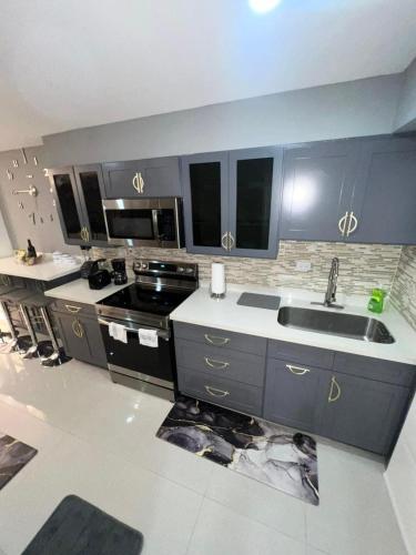 a large kitchen with a sink and a stove at 2 Bedrooms 2 Bathrooms Luxury Gated Condo with Beach and Breathtaking Views of Kingston Harbour and 2 swimming Pools in Portmore