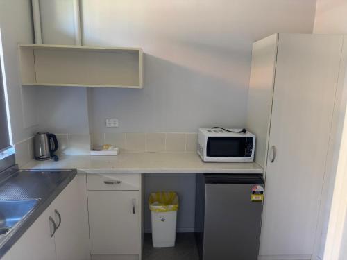 a small kitchen with a microwave on a counter at Mountway Holiday Apartments in Perth