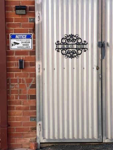 a metal garage door with a sign on it at Sage's in Hay