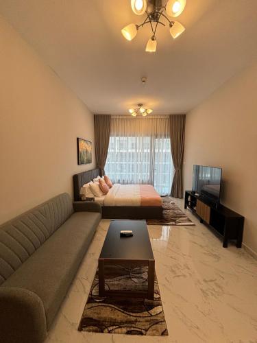 a living room with a bed and a couch at Dream F1 Airport Studio Pool & Gym in Abu Dhabi