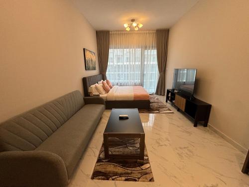 a living room with a couch and a bed at Dream F1 Airport Studio Pool & Gym in Abu Dhabi