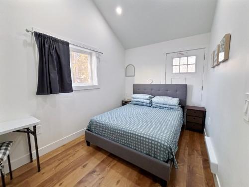 Un dormitorio con una cama y un escritorio y una ventana. en Vancouver’s Homey Laneway House, en Vancouver