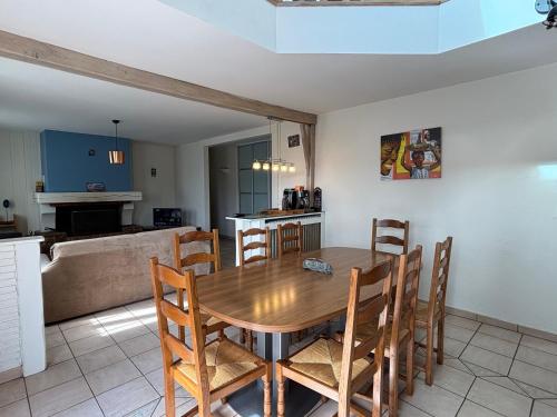 une cuisine et une salle à manger avec une table et des chaises en bois dans l'établissement Villa Sauna & mer, à Sainte-Adresse